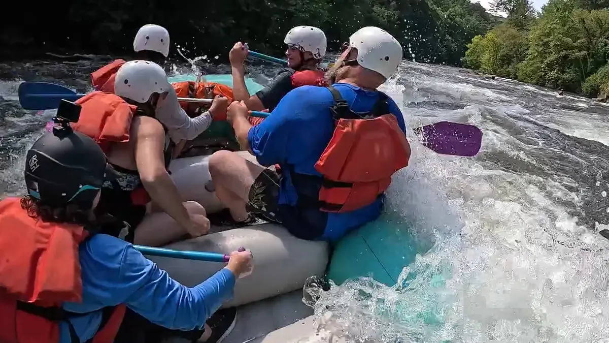 Raft navigating the splashy wave train at Squeeze Play