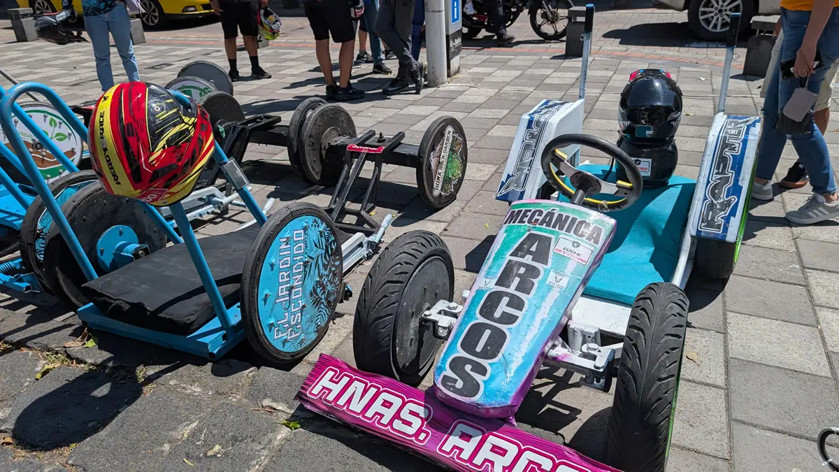 Signage detailing the different vehicle classes for the Carrera de Coches de Madera in Baños, Ecuador