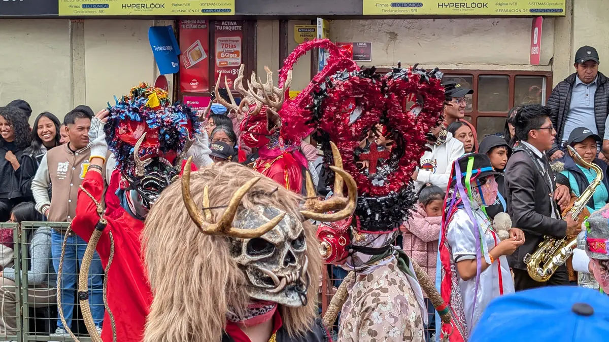 Traditional dancers in elaborate devil masks performing at the Diablada Pillareña festival in Píllaro, Ecuador