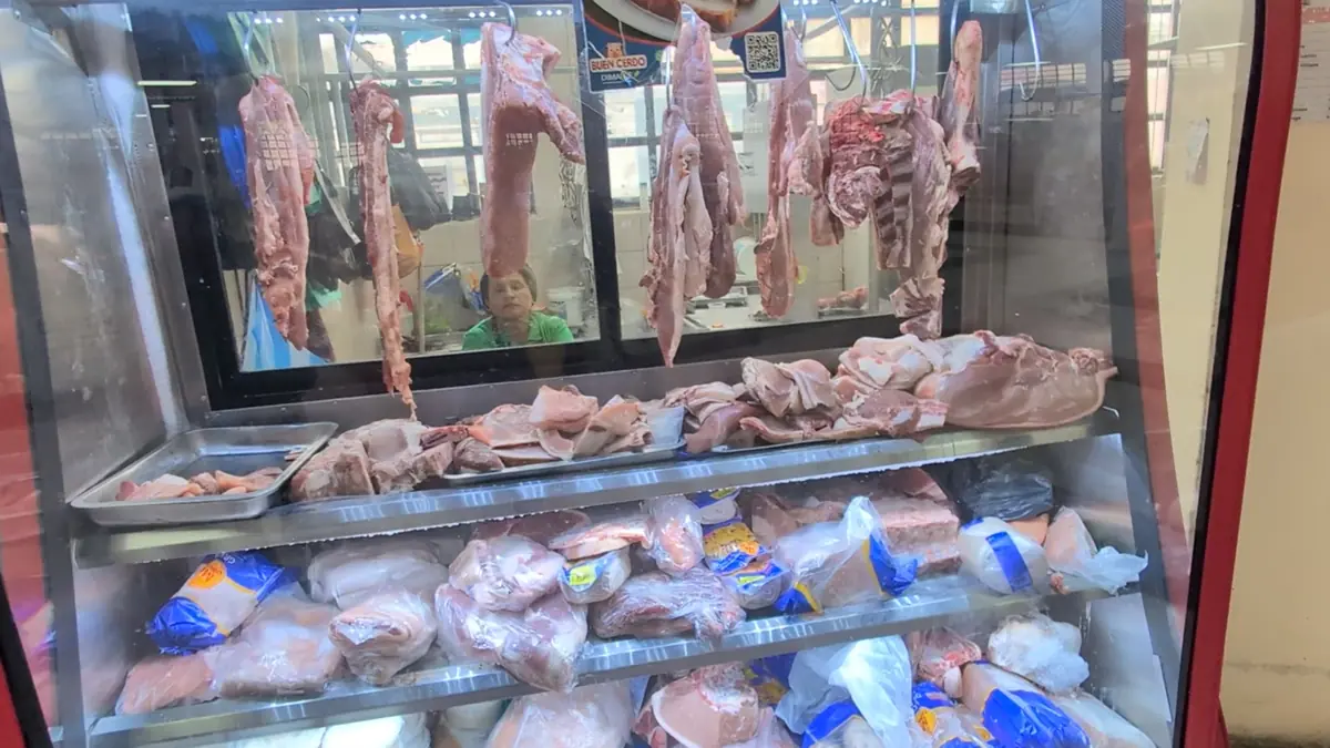 A meat vendor display at Mercado Central in Quito, Ecuador, featuring fresh pork cuts for a local, frugal diet.