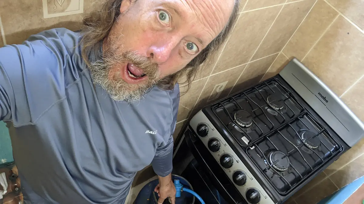 Fast Fred Ruddock demonstrating a compact and efficient camping stove setup, a key tool for maintaining a frugal travel budget.