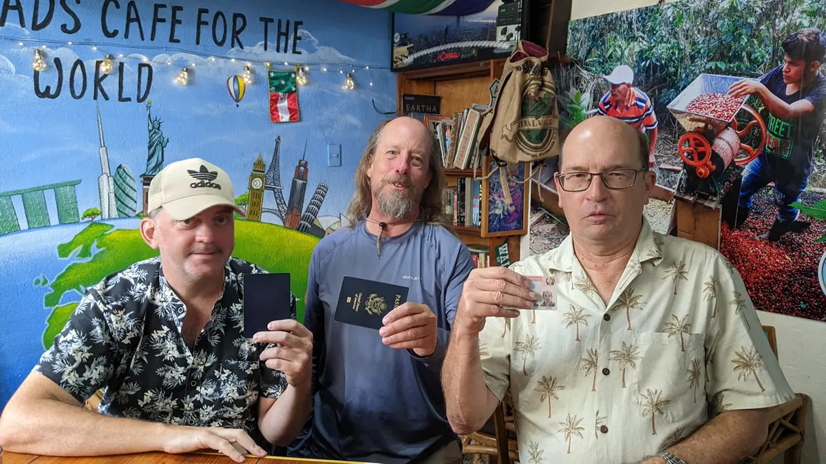 Frugal travel experts Wade Shepard, Fast Fred Ruddock, and Al at Lake Atitlán, Guatemala discussing international travel logistics.