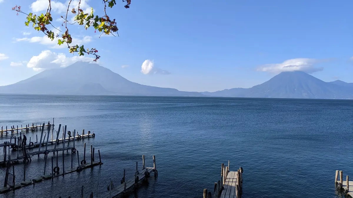 Scenic panoramic view of Lake Atitlán, Guatemala, surrounded by volcanoes and traditional Mayan villages, perfect for frugal travelers.