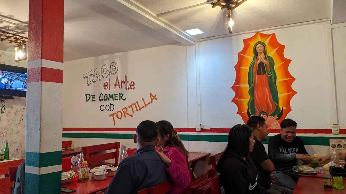 A street food vendor expertly preparing an authentic taco, showcasing the traditional 'art of eating with a tortilla' in Mexico.