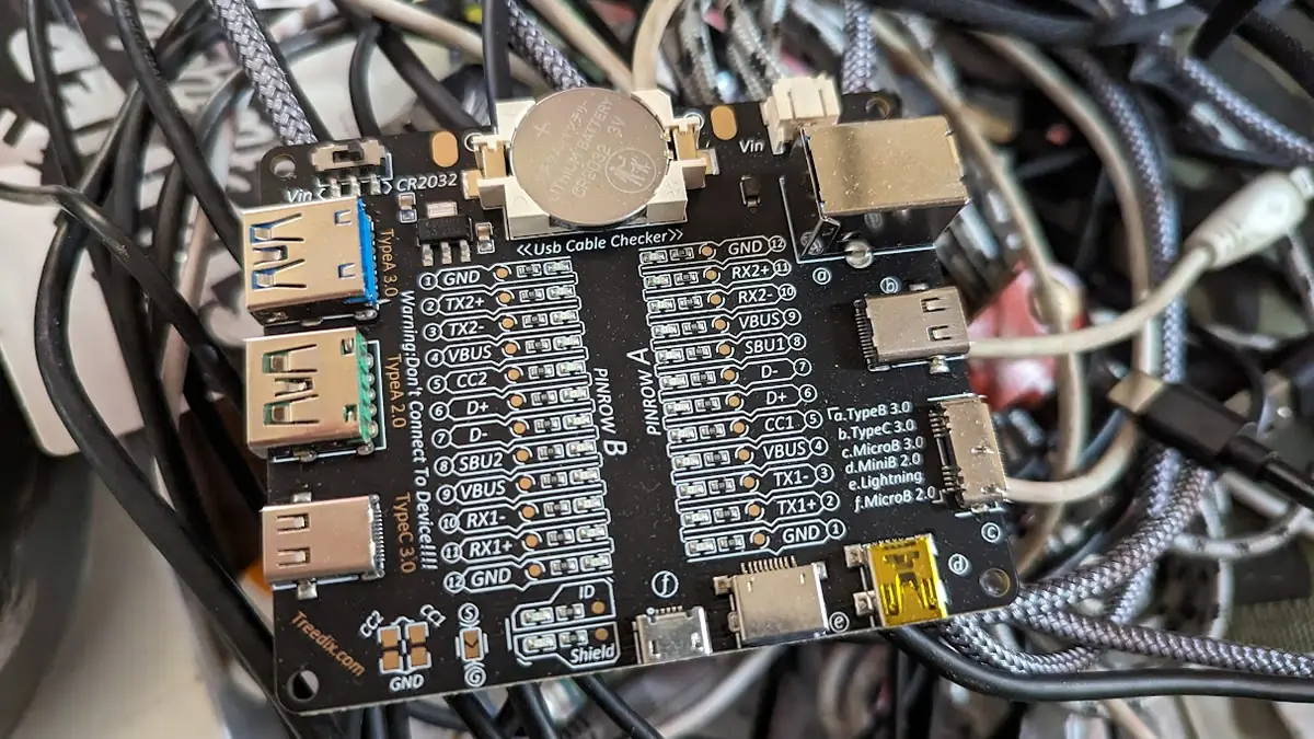 A compact USB cable tester device used by digital nomads to verify charging speeds and data integrity, ensuring reliable tech connectivity while traveling.