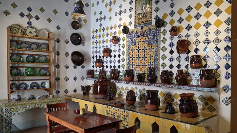 Traditional Mexican kitchen with Talavera tiles and ceramic pottery at Gente de Más Bnb in Puebla