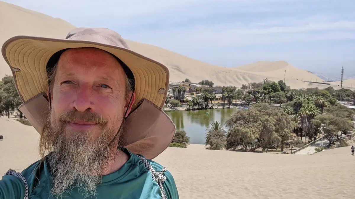 Fast Fred overlooking the Huacachina desert oasis in Peru, surrounded by massive sand dunes.