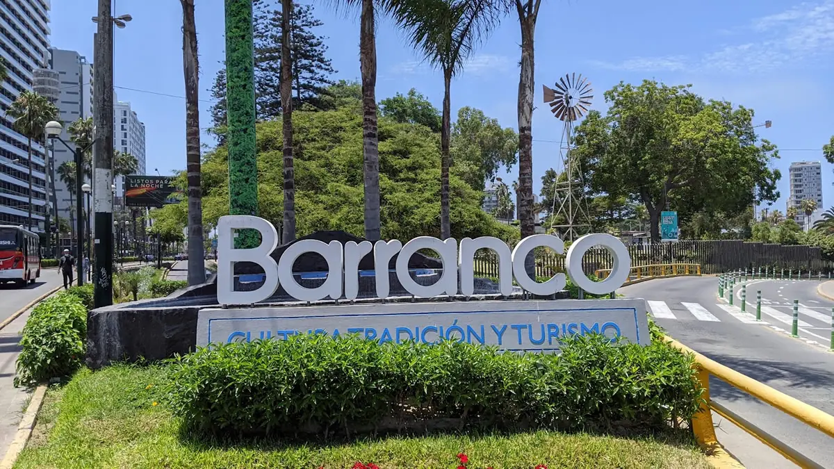 A cityscape view of the Barranco district in Lima, Peru, featuring the colorful neighborhood sign and coastal architecture.